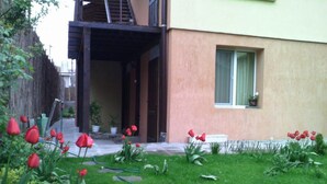 Um edifício residencial com jardim, com tulipas vermelhas e um caminho de pedra.