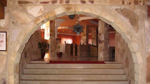 A stone staircase leading to a higher level, with a red carpet and potted plants at the bottom. - Al Rashid Hotel (Wadi Musa)