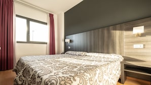 Un dormitorio moderno con una cama grande, cabecera de madera y una ventana con cortinas.