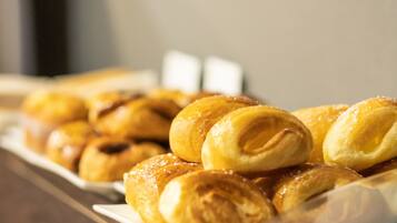 A tray of freshly baked pastries, likely croissants, arranged on a white plate.
