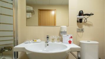 A bathroom with a white sink, a mirror, a towel rack, a hairdryer, and a toilet.