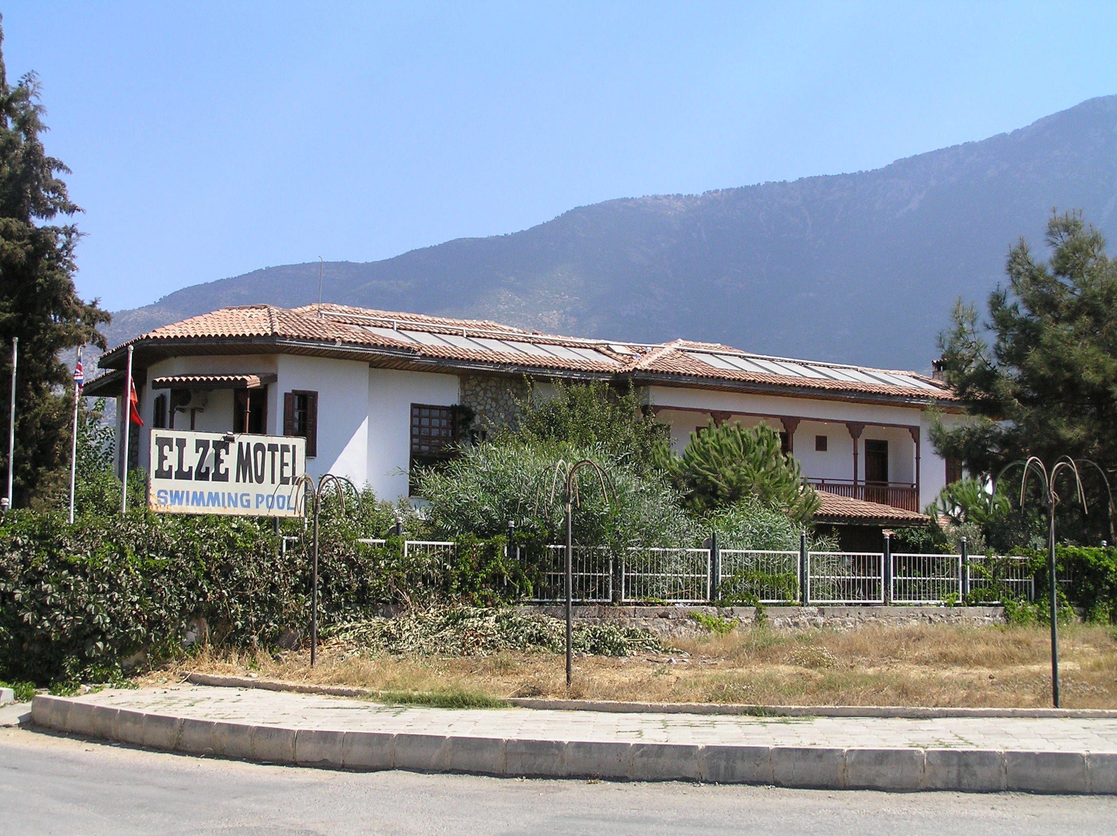 Un edificio de dos pisos con un letrero que dice 'ELZE MOTEL SWIMMING POOL'.