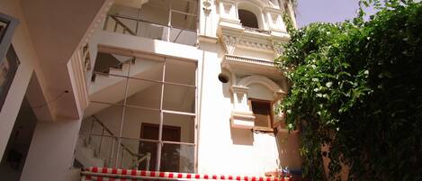 Un edificio de varios pisos con un balcón y un toldo a rayas rojas y blancas.
