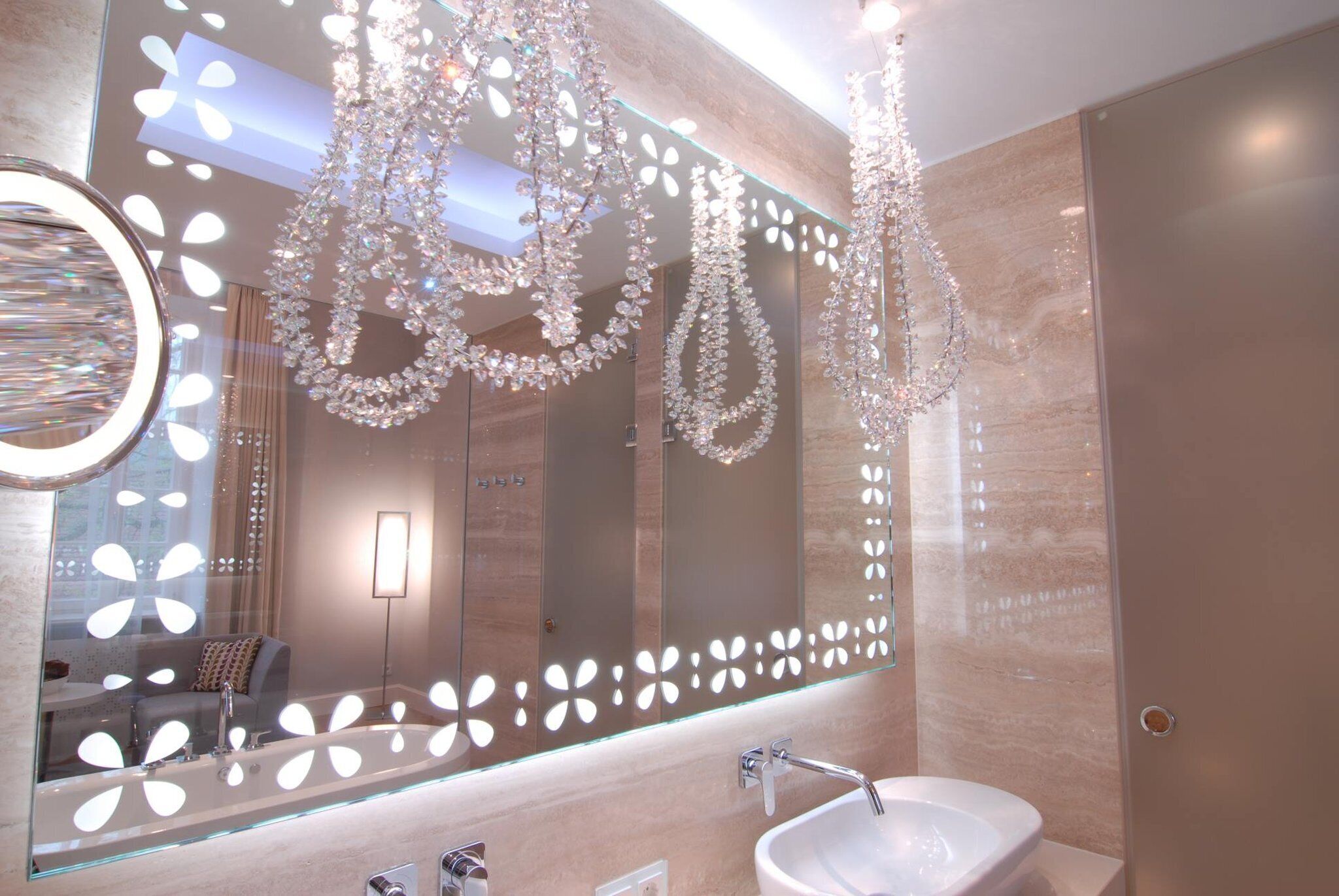 Une salle de bain moderne avec un grand miroir, un lavabo et un espace douche.