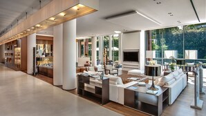 A spacious, modern living area with a large sofa set, a coffee table, and a television. - Hotel Principe Forte dei Marmi (Forte dei Marmi)