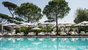 A poolside area with lounge chairs and umbrellas, surrounded by trees. - Hotel Principe Forte dei Marmi (Forte dei Marmi)