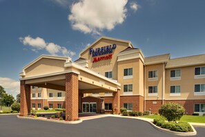 Ein Fairfield Inn & Suites Marriott Hotel mit Backsteinfassade, überdachter Eingangszone und begrüntem Vorgarten.