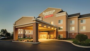 Un hôtel Fairfield Inn & Suites Marriott avec une façade en briques, une entrée abritée et un parking.