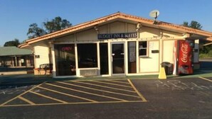 A building with a sign reading "Budget Inn & Suites" with a parking lot in front. - Budget Inn And Suites (Abbeville)