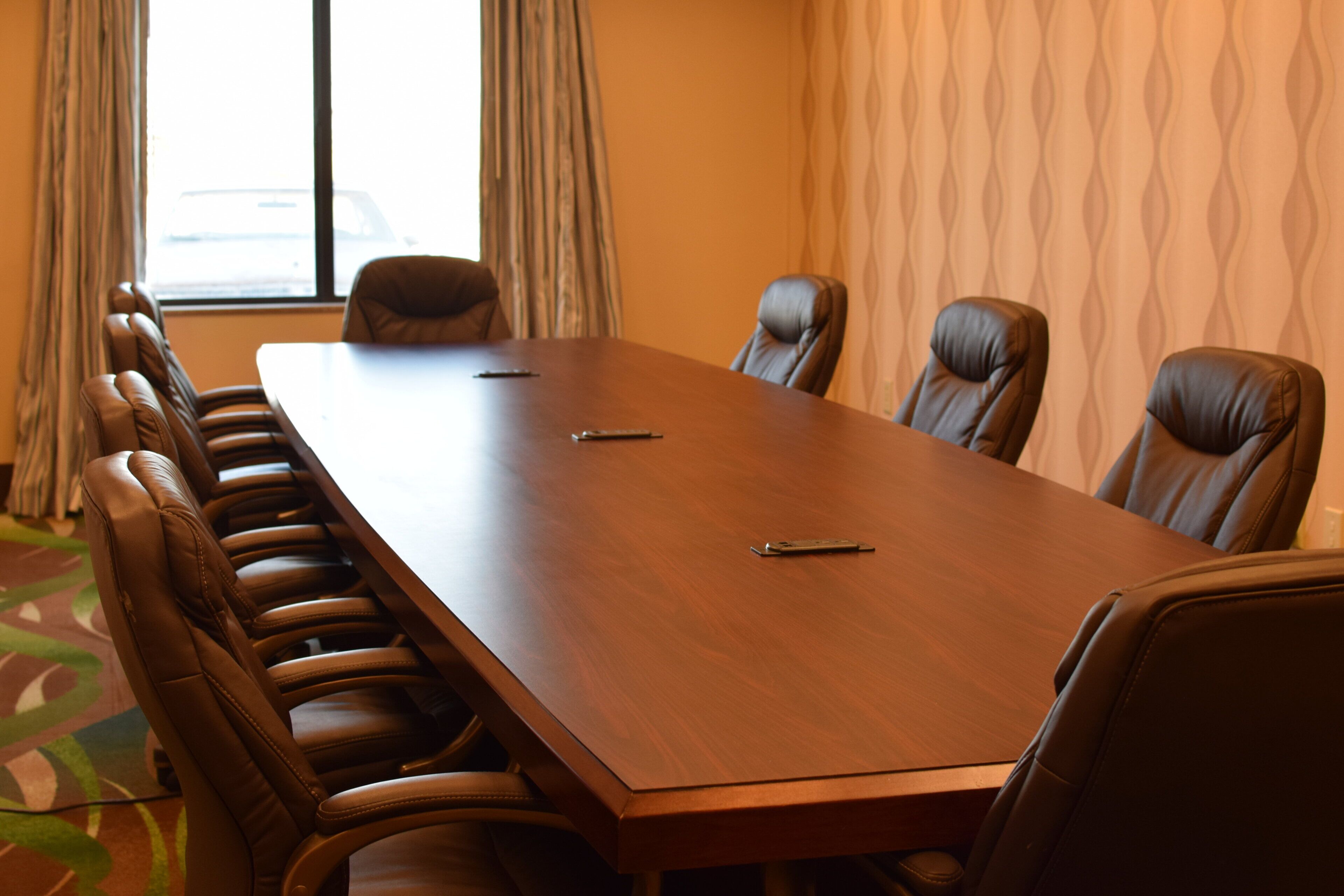 A conference room with a long table and leather chairs.