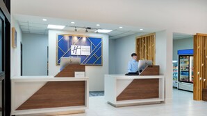 A Holiday Inn Express reception area with two reception desks, a blue and white logo, and a modern design. - Holiday Inn Express Hotel & Suites Pratt by IHG (Pratt)