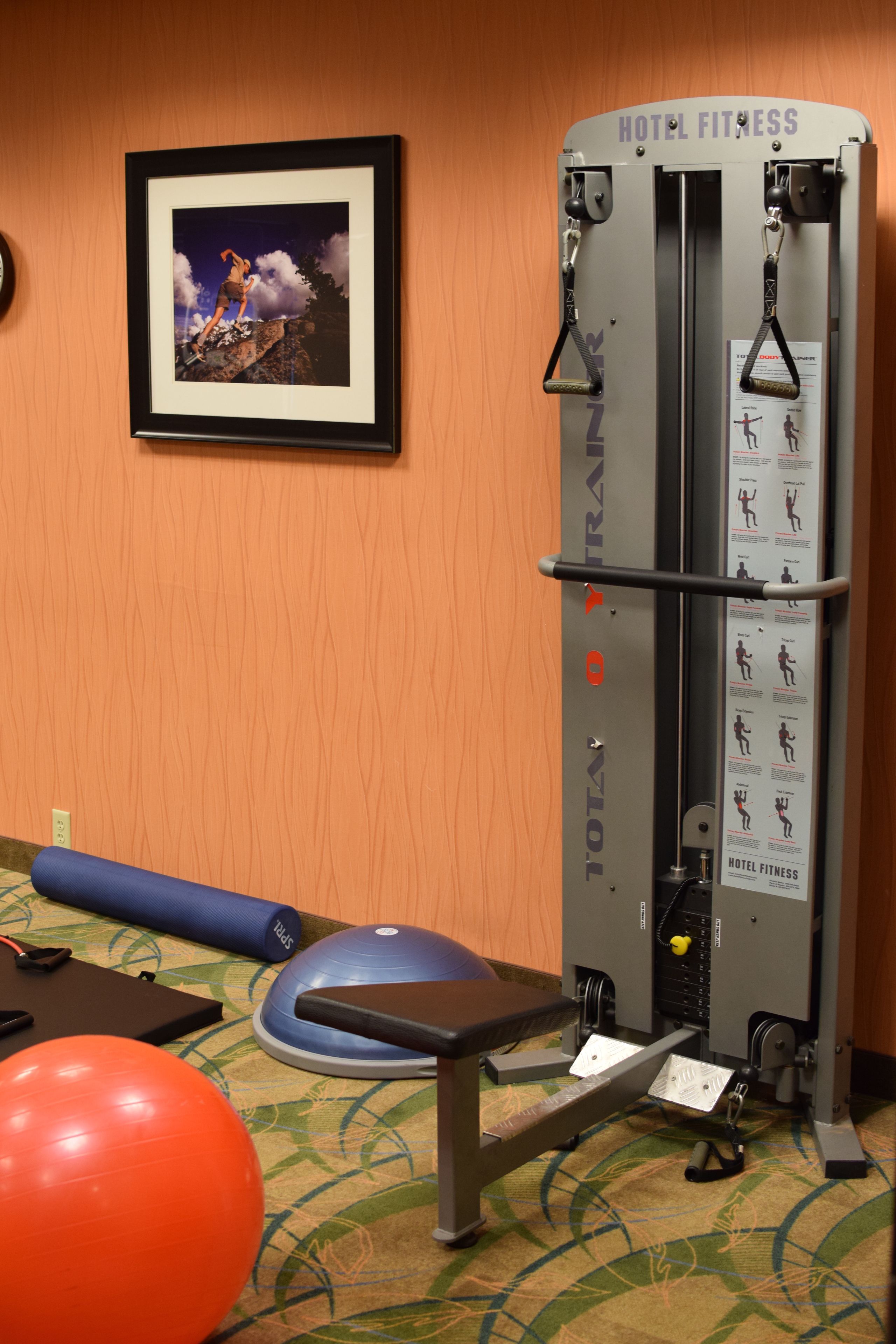 A hotel fitness center with a pull-up bar, exercise ball, and a bench.