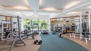 A gym with cardio machines, weightlifting equipment, and a green carpet. - Henann Garden Resort (Boracay Island)