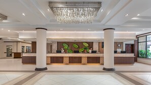A spacious lobby with a reception desk, large columns, and a chandelier. - Henann Garden Resort (Boracay Island)