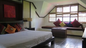 A bedroom with a bed, a bench, and a window with blinds. - Bahura Resort and Spa (Zamboanguita)