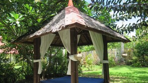 A wooden gazebo with a thatched roof, a blue mattress, and white curtains. - Bahura Resort and Spa (Zamboanguita)