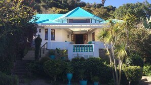 A two-story house with a blue roof, a front porch, and a swimming pool. - Mont Fleur B&B (Wilderness)