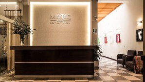 A reception desk with a sign reading "MAYTAQ WASTIN BOUTIQUE HOTEL". - Maytaq Wasin Hotel (Cusco)