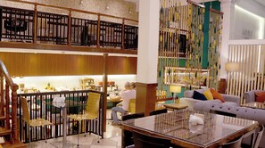 A spacious interior with a dining area, seating arrangements, and a kitchen visible in the background. - Maytaq Wasin Hotel (Cusco)