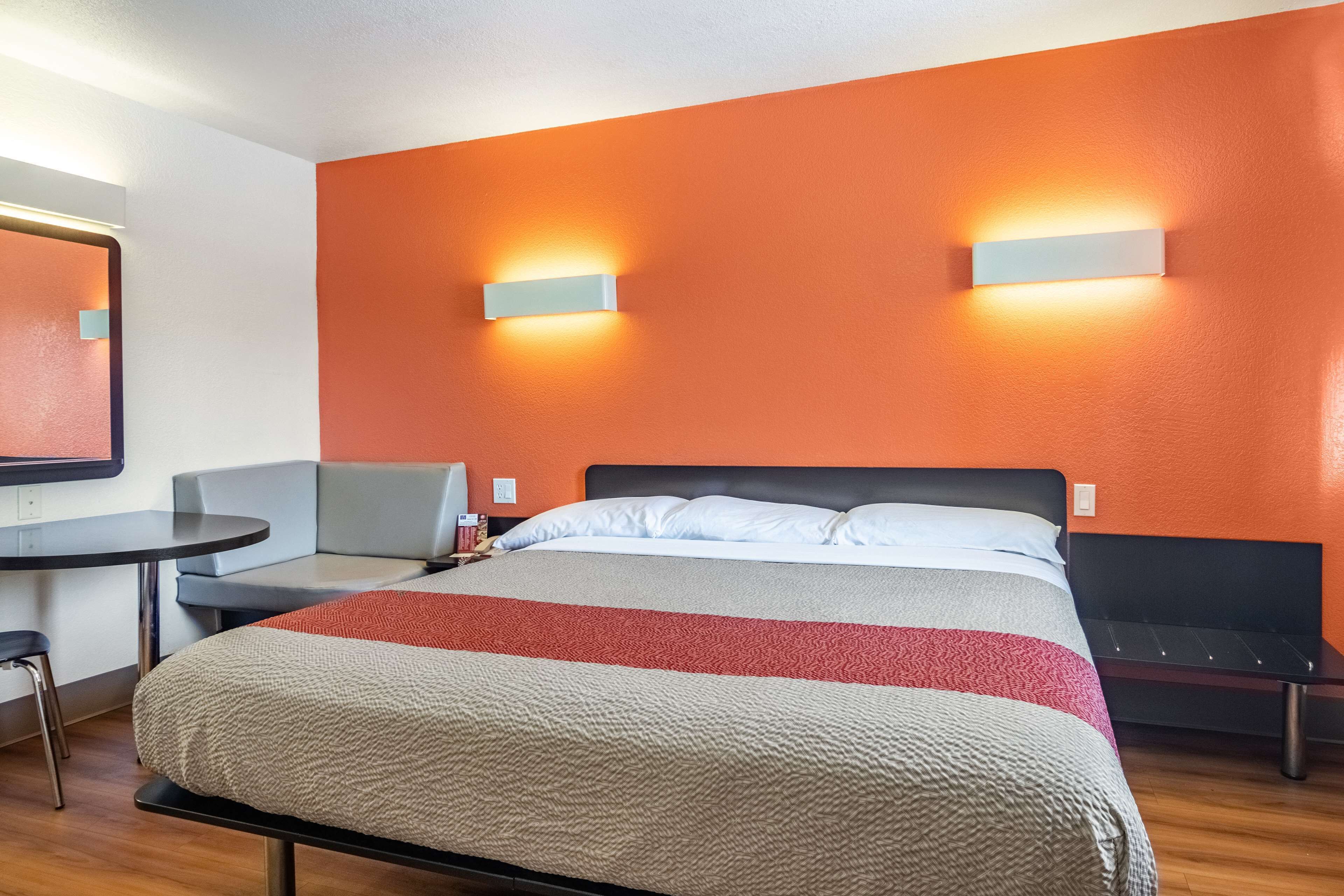 A hotel room with a bed, a desk, and a chair.
