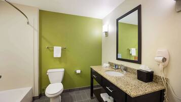 A bathroom with a toilet, sink, vanity, and a hairdryer.