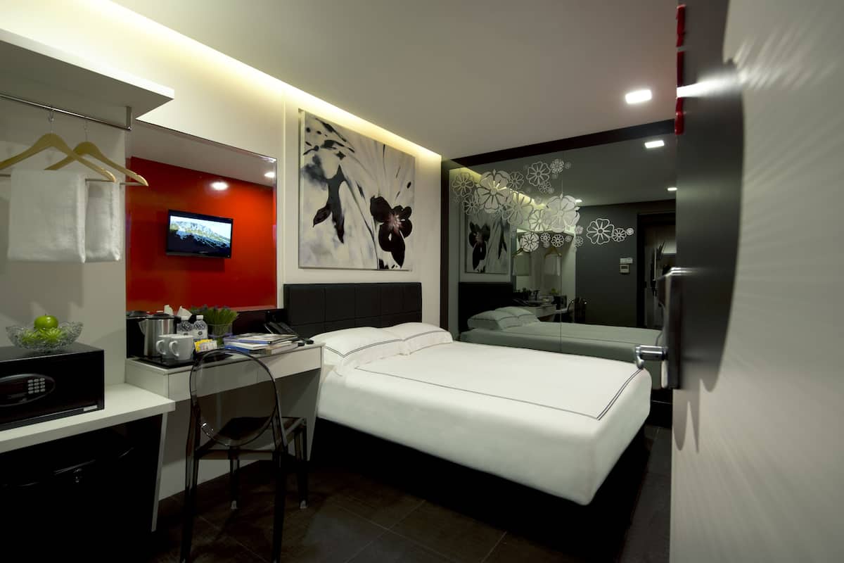 Una habitación de hotel moderna con cama, escritorio y televisión.