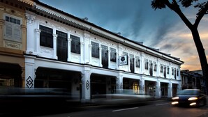 A historic building with a white facade, multiple windows, and a sign that reads "VENUE". - Venue Hotel (Singapore)
