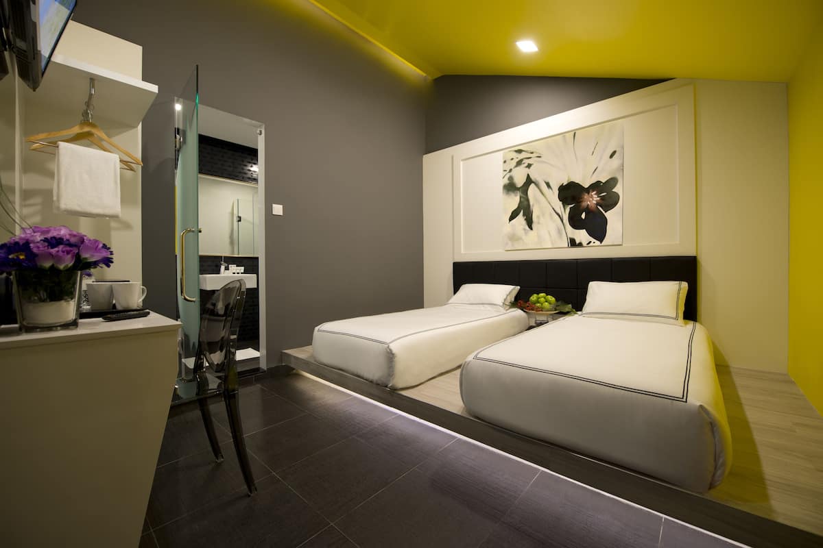 Una habitación de hotel moderna con cama, mesita de noche y espejo.