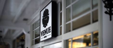 A hotel sign with the word "VENUE" and a graphic of a fan.