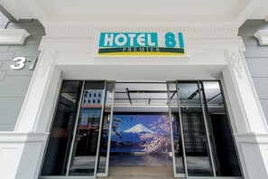 The entrance of Hotel 81 Premier with a large sign above the doors, a view of Mount Fuji through the glass, and a number '31' on the wall. - Hotel 81 Premier Star (Singapore)