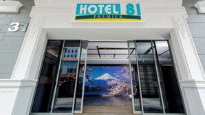 A hotel entrance with a sign reading "HOTEL 81 PREMIER" and a large window displaying a view of Mount Fuji. - Hotel 81 Premier Star (Singapore)
