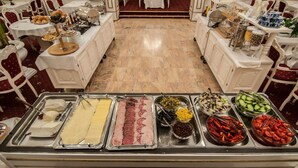 A buffet setup with various food items and utensils. - Hotel Imparatul Romanilor (Sibiu)