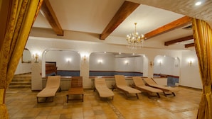 A spa area with multiple sun loungers, a reception desk, and a staircase leading to an upper level. - Hotel Imparatul Romanilor (Sibiu)