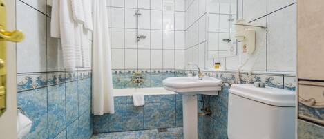 Un baño con bañera, lavabo e inodoro.