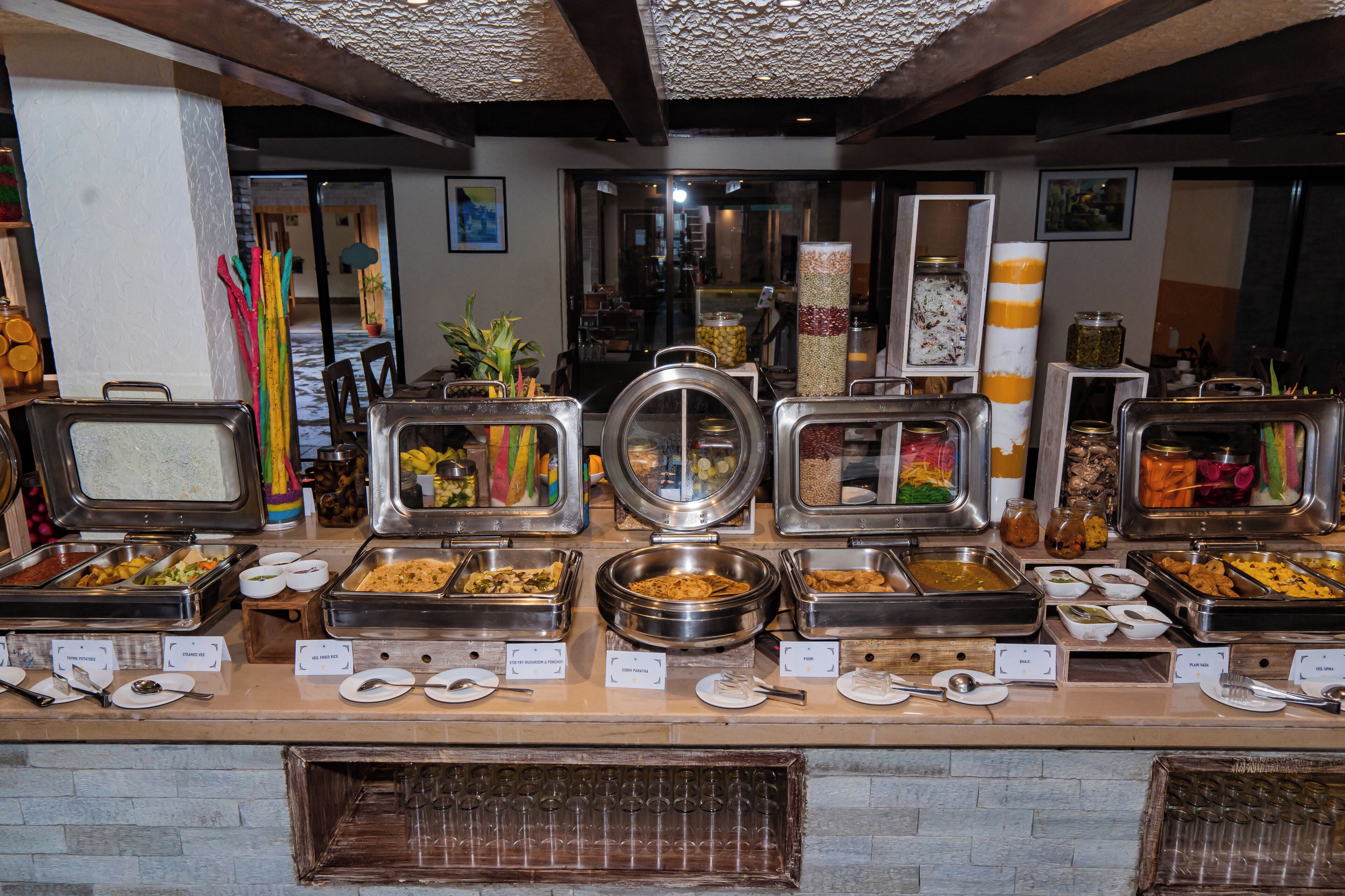 A buffet with various food options and utensils.