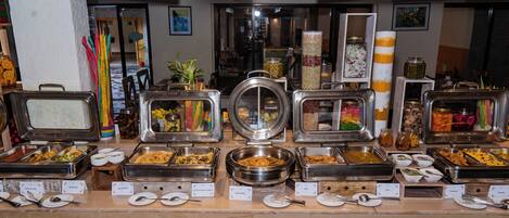 A buffet with various food options and utensils.