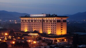A large, multi-story hotel with a prominent sign reading "COMMODORE". - Commodore Hotel Gyeongju (Gyeongju)