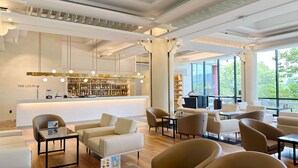A modern lounge area with a bar, seating, and large windows offering a view of the outdoors. - Commodore Hotel Gyeongju (Gyeongju)