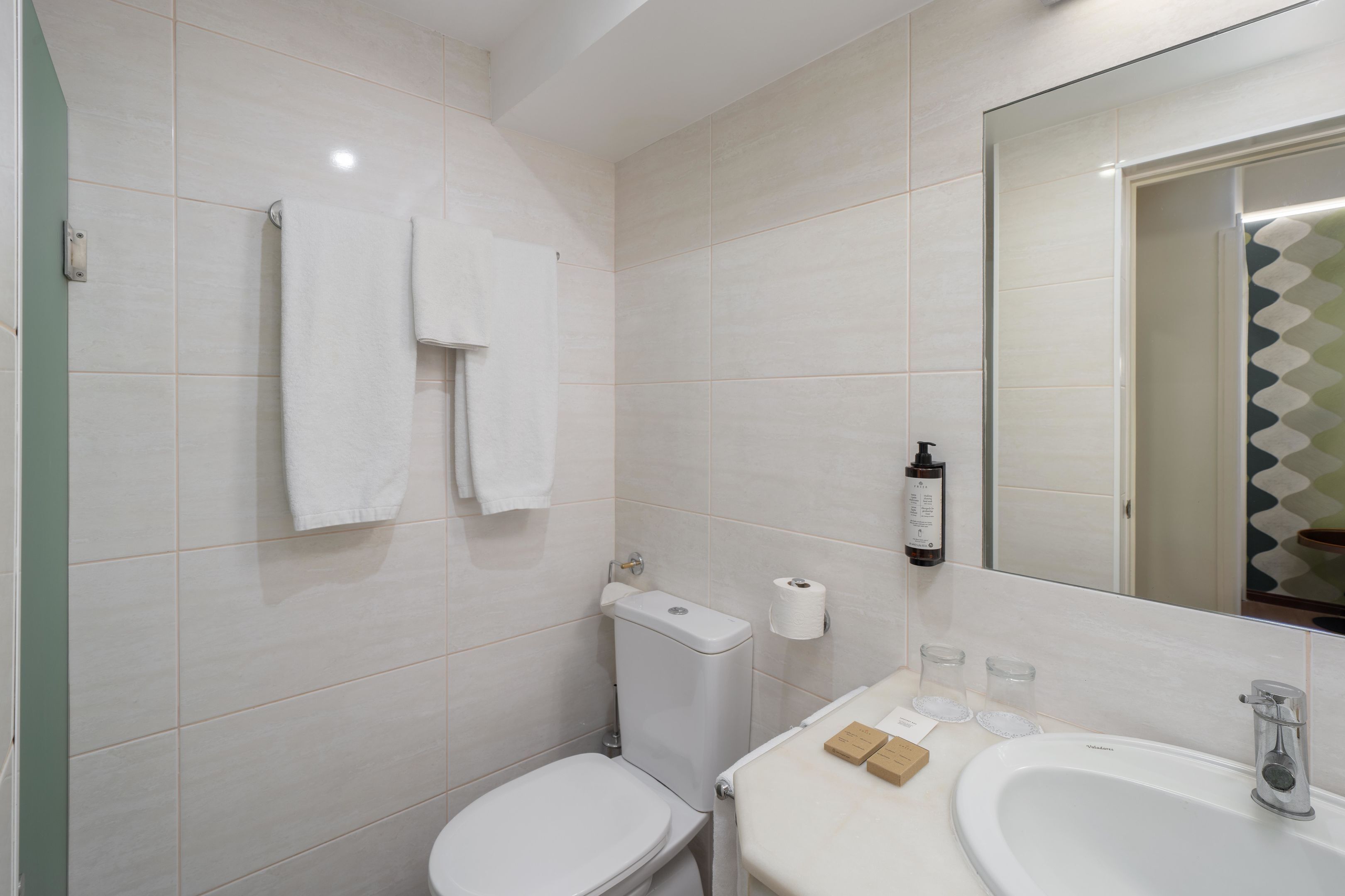 Une salle de bain avec des toilettes, un lavabo et un miroir.