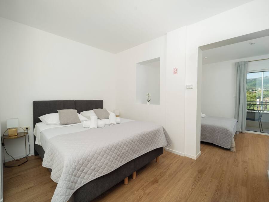 Un dormitorio moderno con cama, mesita de noche y vistas al exterior.