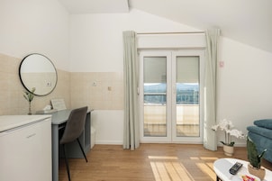 Habitación de hotel con escritorio, silla y vistas a través de la puerta.