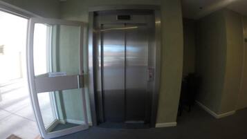 Un ascensor con puerta de vidrio y panel de control.