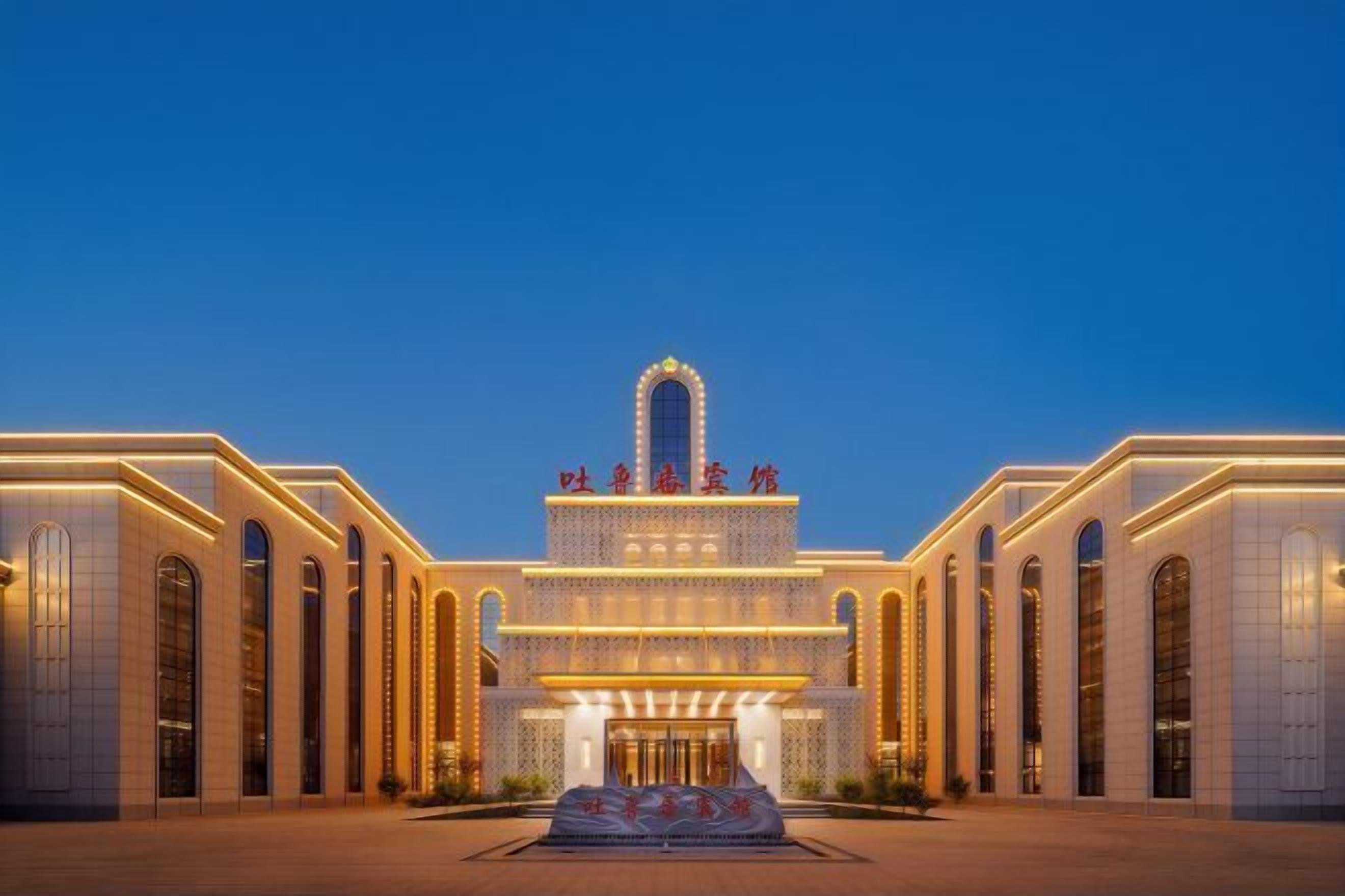 A grand hotel with a central arched entrance, multiple levels, and a symmetrical facade.