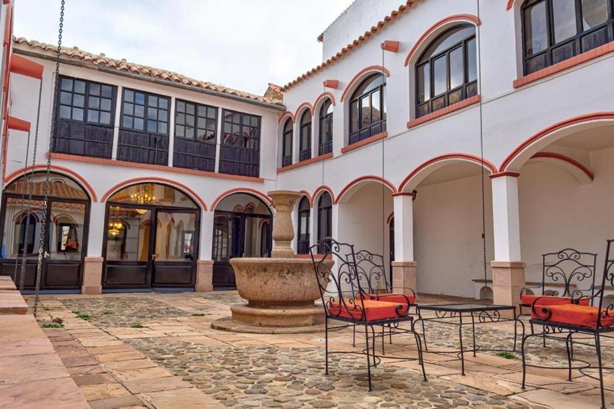 A courtyard with stone flooring, outdoor seating, and a large planter.