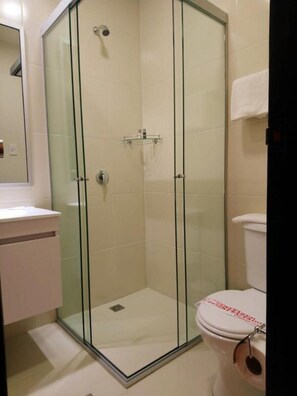 A bathroom with a glass-enclosed shower, a toilet, and a sink. - Colonial Hostal (Potosi)