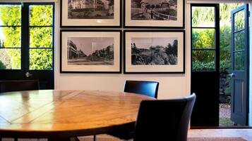 A conference room with a wooden table, four chairs, and four framed black and white photographs on the wall.