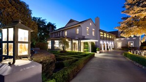 A large, modern building with a covered walkway and a well-maintained garden. - Mineral Springs Hotel (Hepburn Springs)