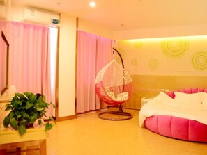 Una habitación con una silla colgante, una cama y una planta.
