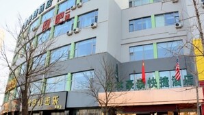 Un edificio de varios pisos con letreros que señalan un hotel y un restaurante.