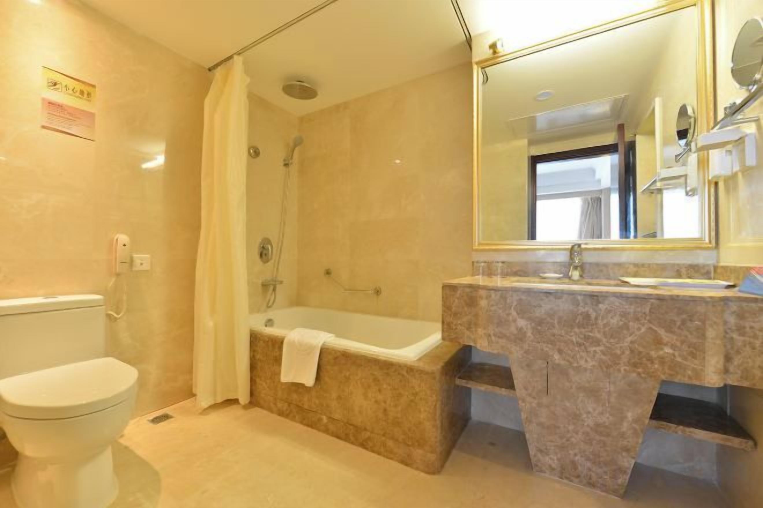 A bathroom with a toilet, a shower, a bathtub, and a sink with a mirror.